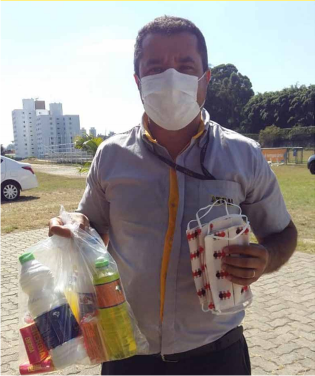 Pai de aluna do Projeto Meninas em Campo recebendo kits de higiene e máscaras doados pelos pais